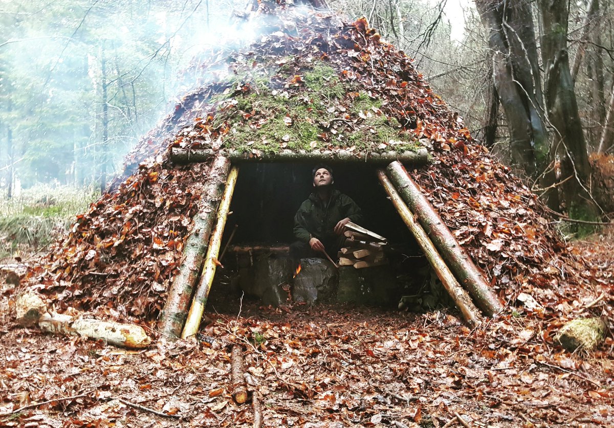 NISurvival's tweet photo. Experimenting with shelter configurations and smoke draw. A mixture of smoke and steam billows off the roof after a heavy downpour. #wildernesskills https://t.co/ZYQ3do2B2c