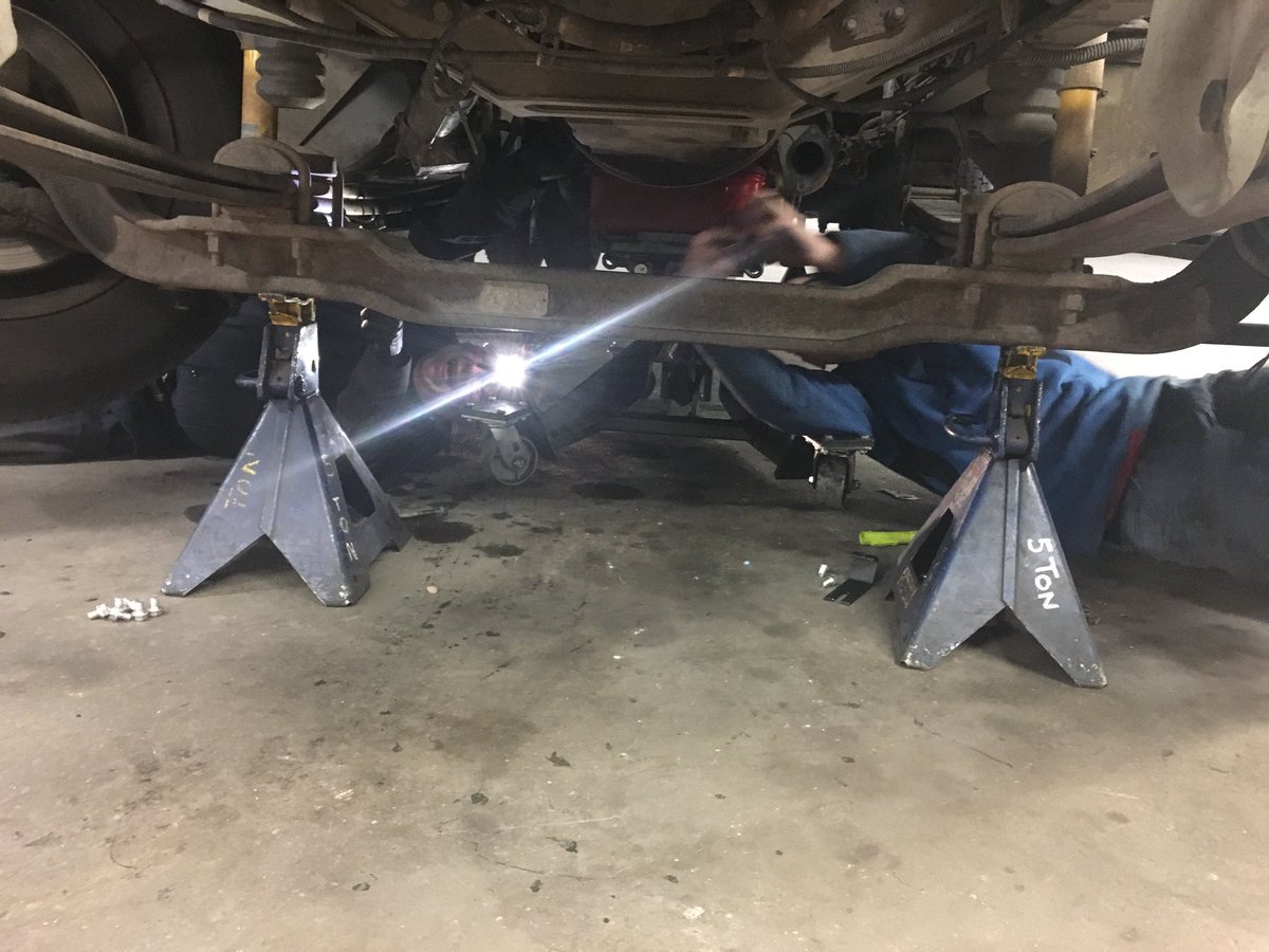 Team work in a safe manner. Jude and Colyn working together to accomplish their work. Both caught safely under the truck using all the safety equipment.