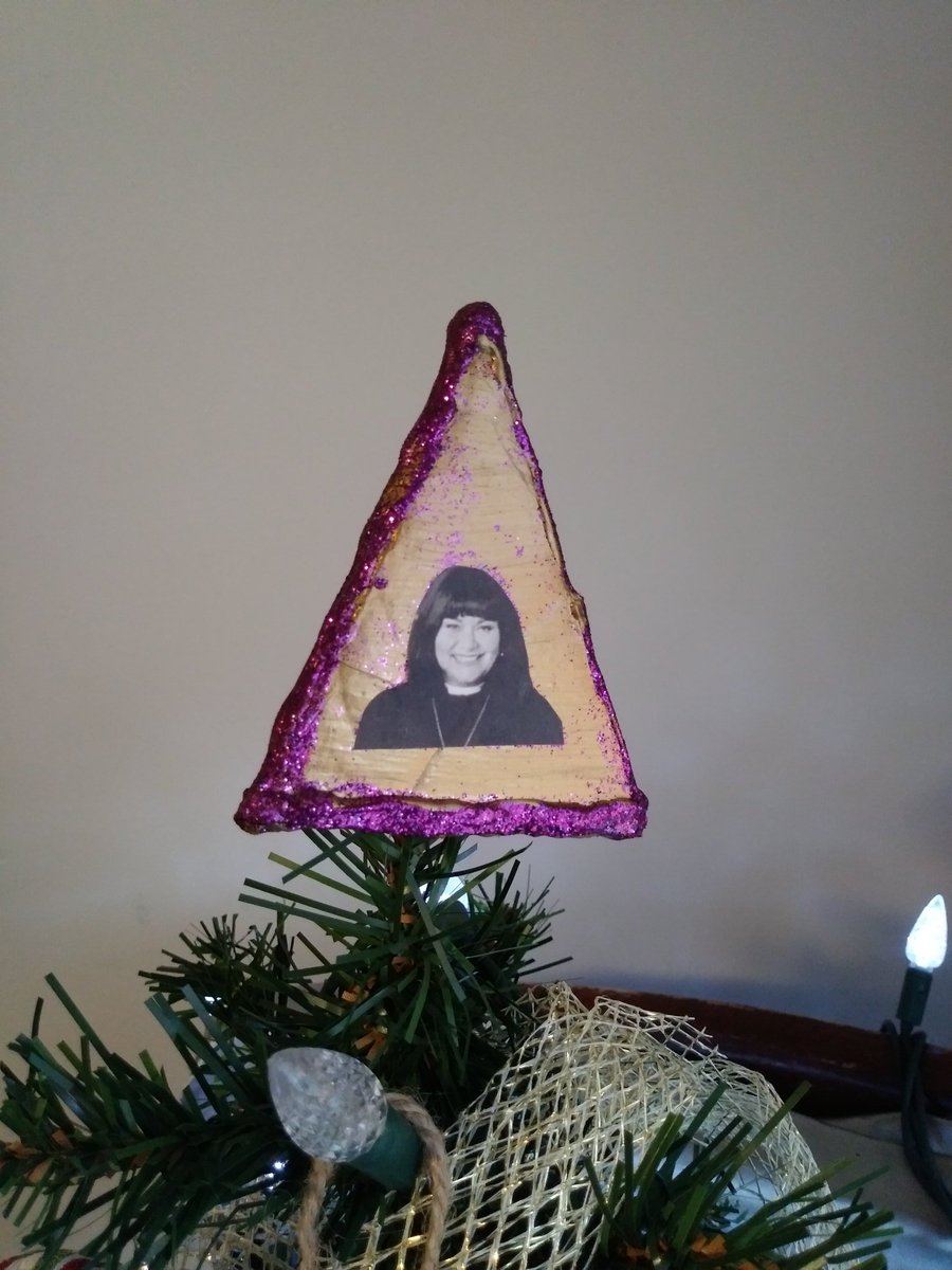 mergzatroid's tweet photo. Mine and @periculumco's very small Christmas tree, topped with our three-tiered, obviously handmade British angel. An actual angel, an Anglican vicar and a Catholic priest. π #aziraphale #vicarofdibley #fathermarcus https://t.co/h6lvMYiba2