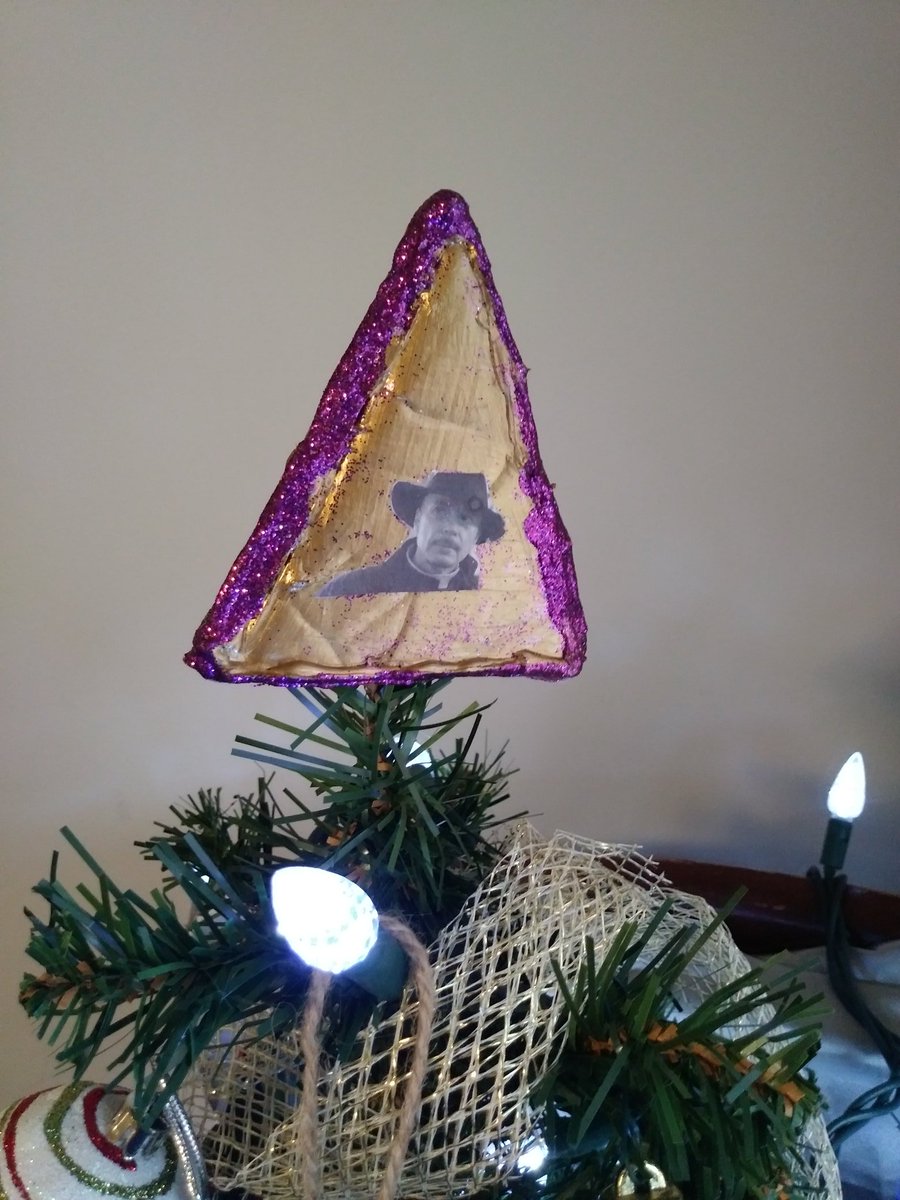 mergzatroid's tweet photo. Mine and @periculumco's very small Christmas tree, topped with our three-tiered, obviously handmade British angel. An actual angel, an Anglican vicar and a Catholic priest. π #aziraphale #vicarofdibley #fathermarcus https://t.co/h6lvMYiba2