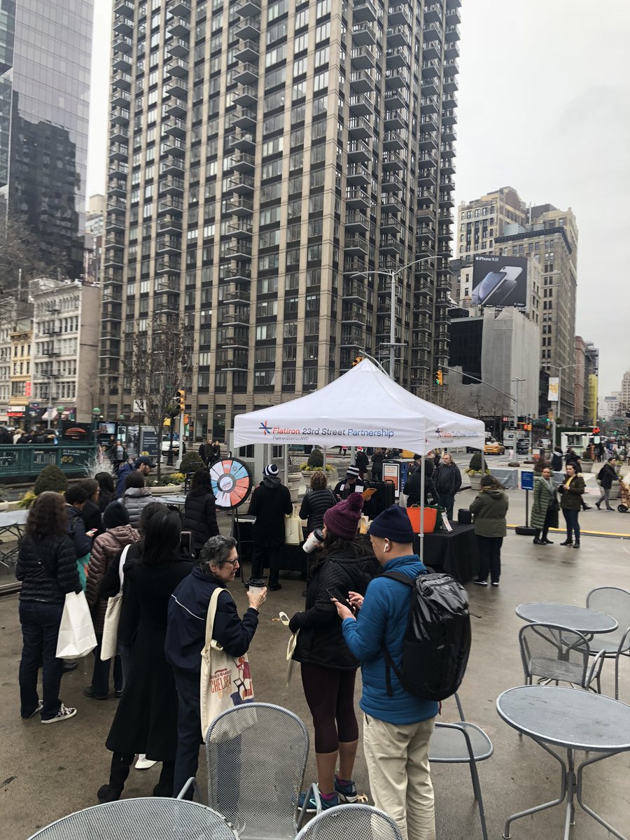 FlatironNY's tweet photo. Wet weather doesn't stop the #23DaysofFlatironCheer! Stop by 'til 4pm:

✔️ Free @shakeshack hot chocolate🍫 
✔️ Food Drive for @FoodBank4NYC🥪
✔️ @SonySquareNYC gift 🎞
✔️ Tote Bag w/discounts 🛍
✔️ Prize Wheel! 🎁

Share pics with #HappyinFlatiron for a chance to win a prize! https://t.co/wqE0cihZM7