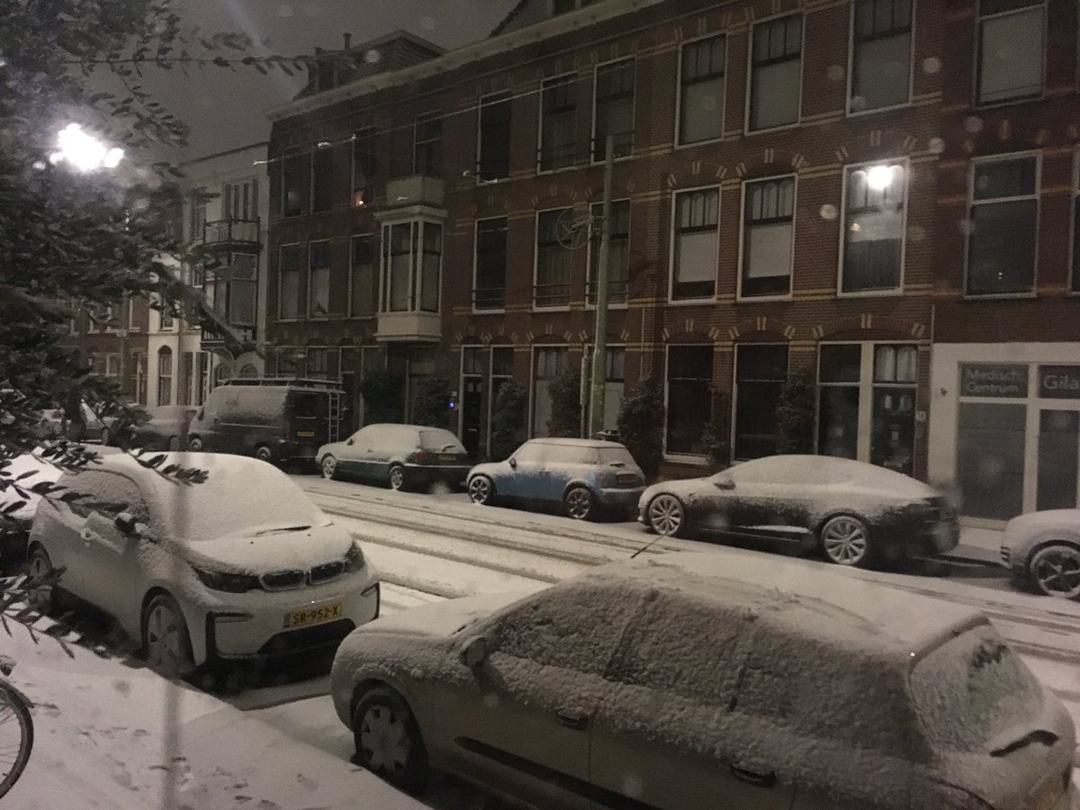 A rugular street in #thehaque #Netherlands tonight: snow and 2 #ev electric vehicules (unplugged, So no range anxiety)! #tesla #i3