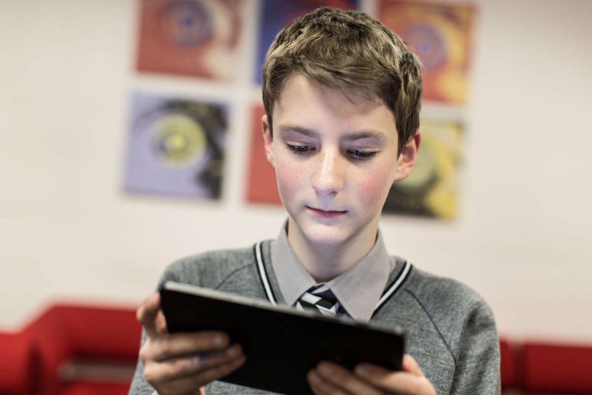 Image shows young boy using a tablet.