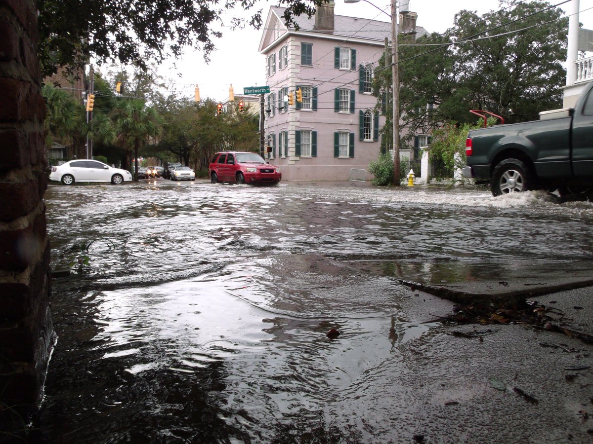 This image shows cars traveling through water-covered streets during a high tide flooding event in Charleston, South Carolina, in 2017.
