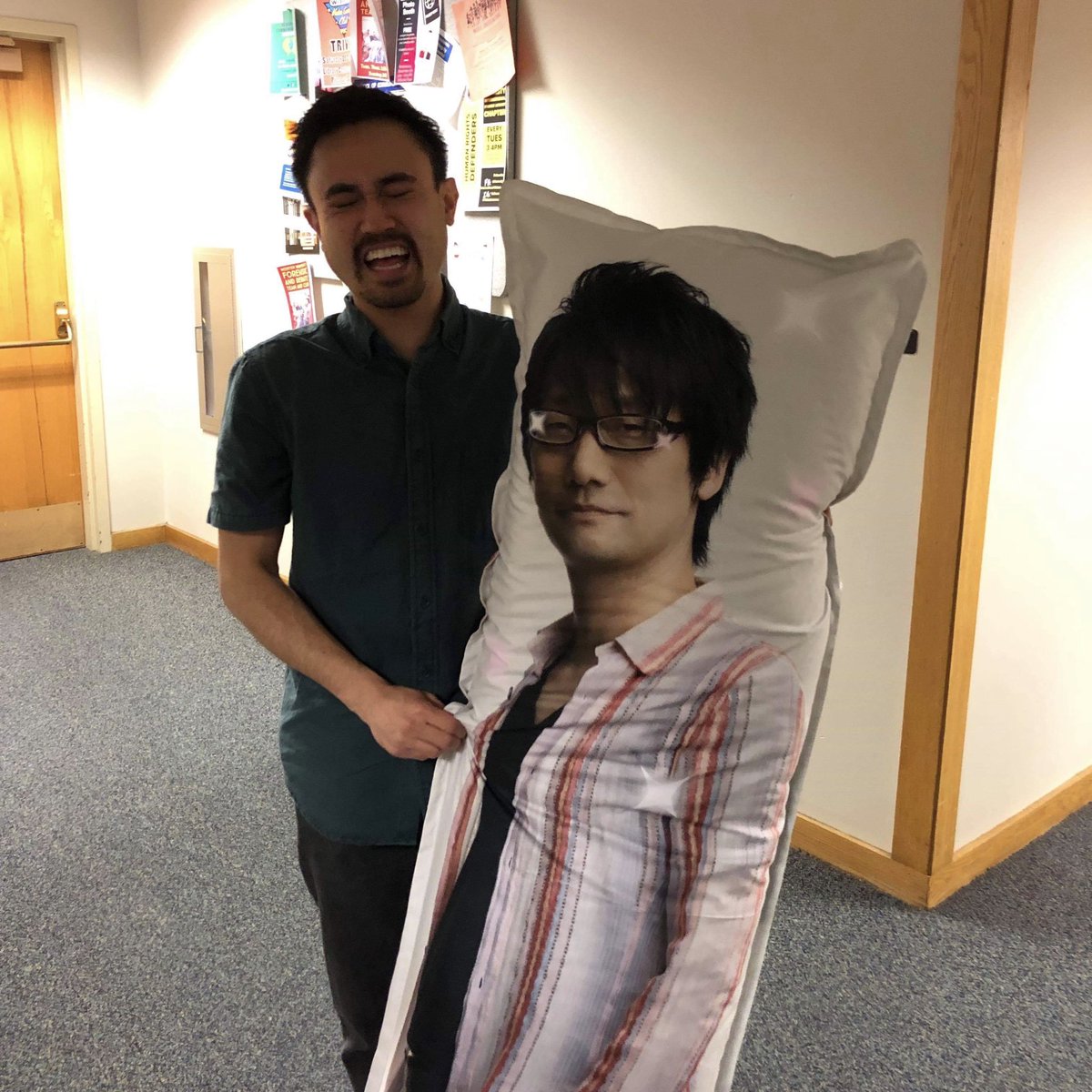 robmsantos's tweet photo. I have never come so close to crying from laughter. To my Video Game Production class, may you ship games until you too are awkwardly gifted to professors like this @HIDEO_KOJIMA_EN pillow. #gamedev #gameprof https://t.co/0NYxcgXNg0