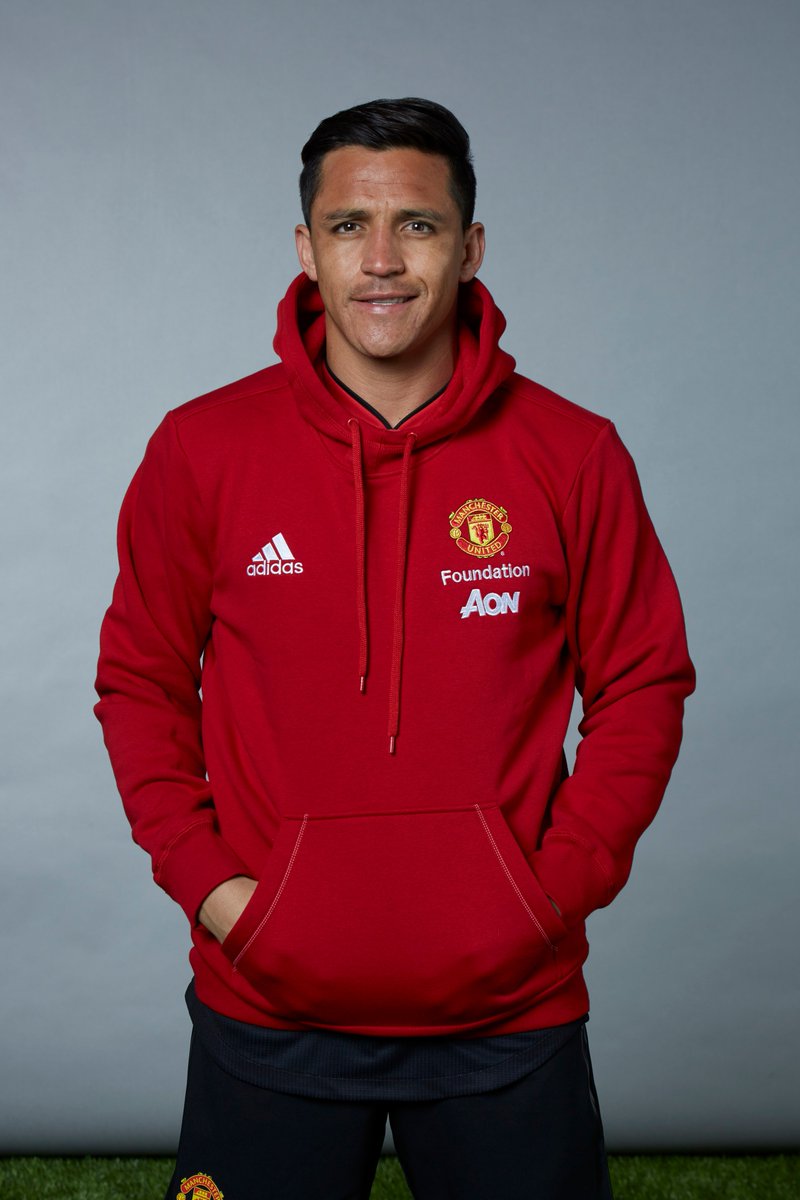 Alexis Sanchez wearing a red Manchester United Foundation hoodie.