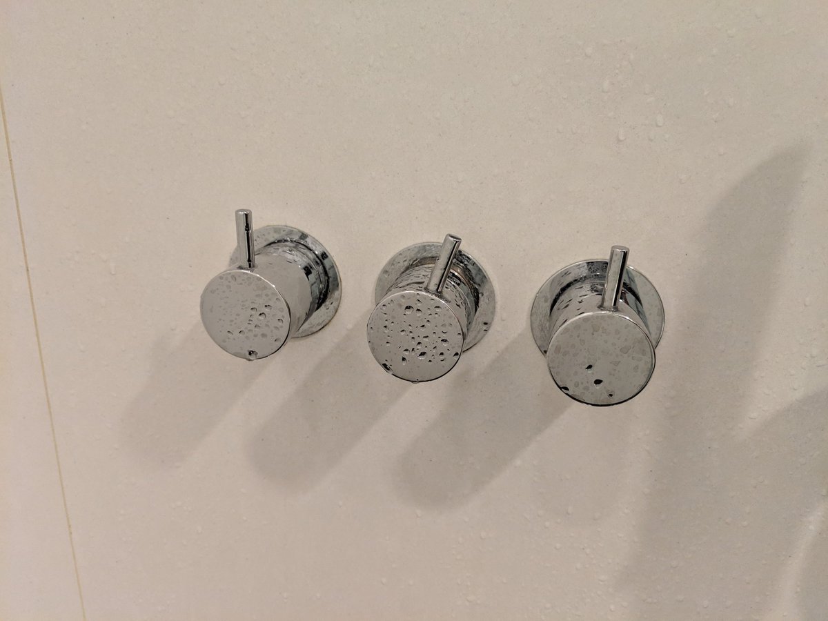 Three identical dials in a shower.