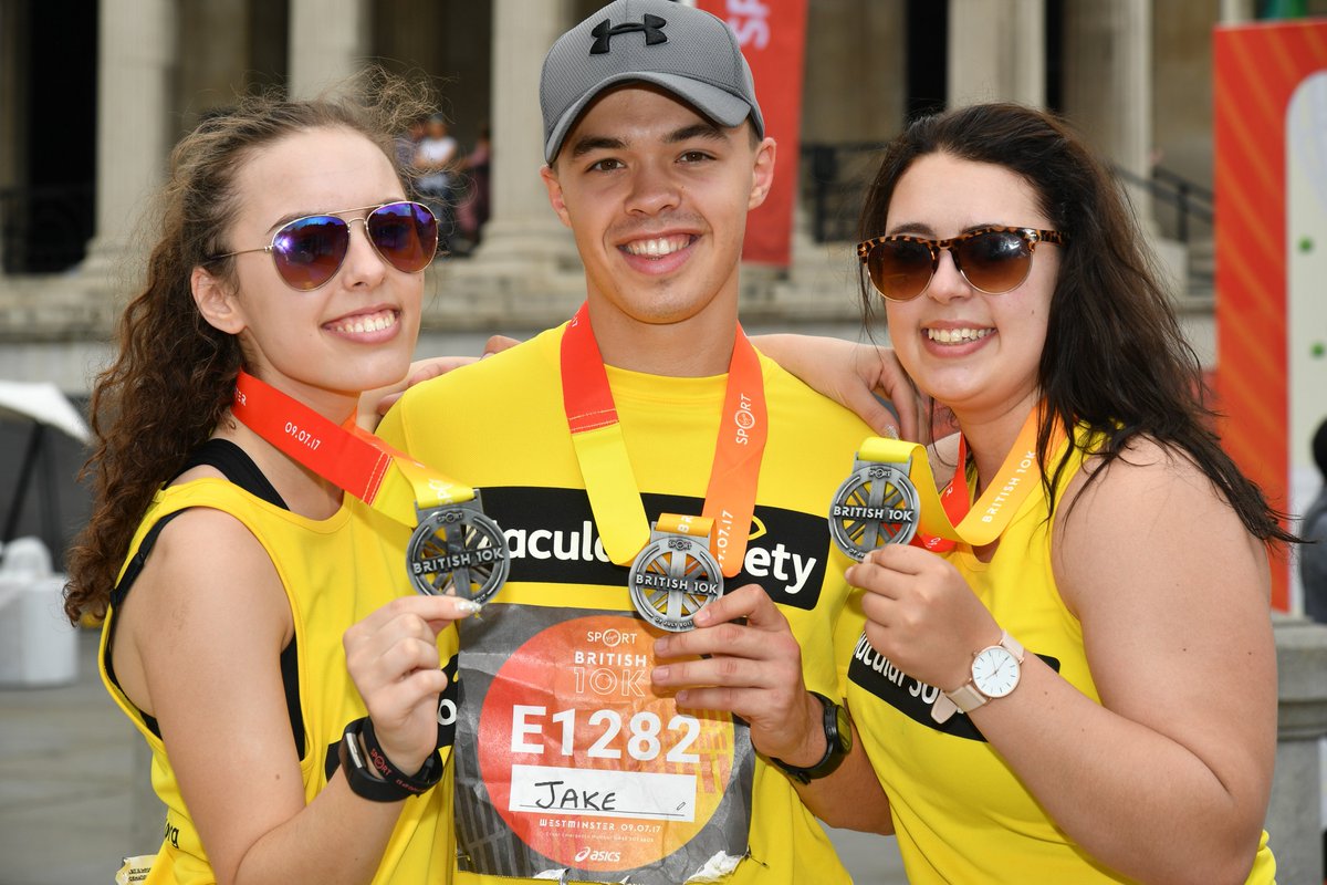 Runners at London 10k holding up medals