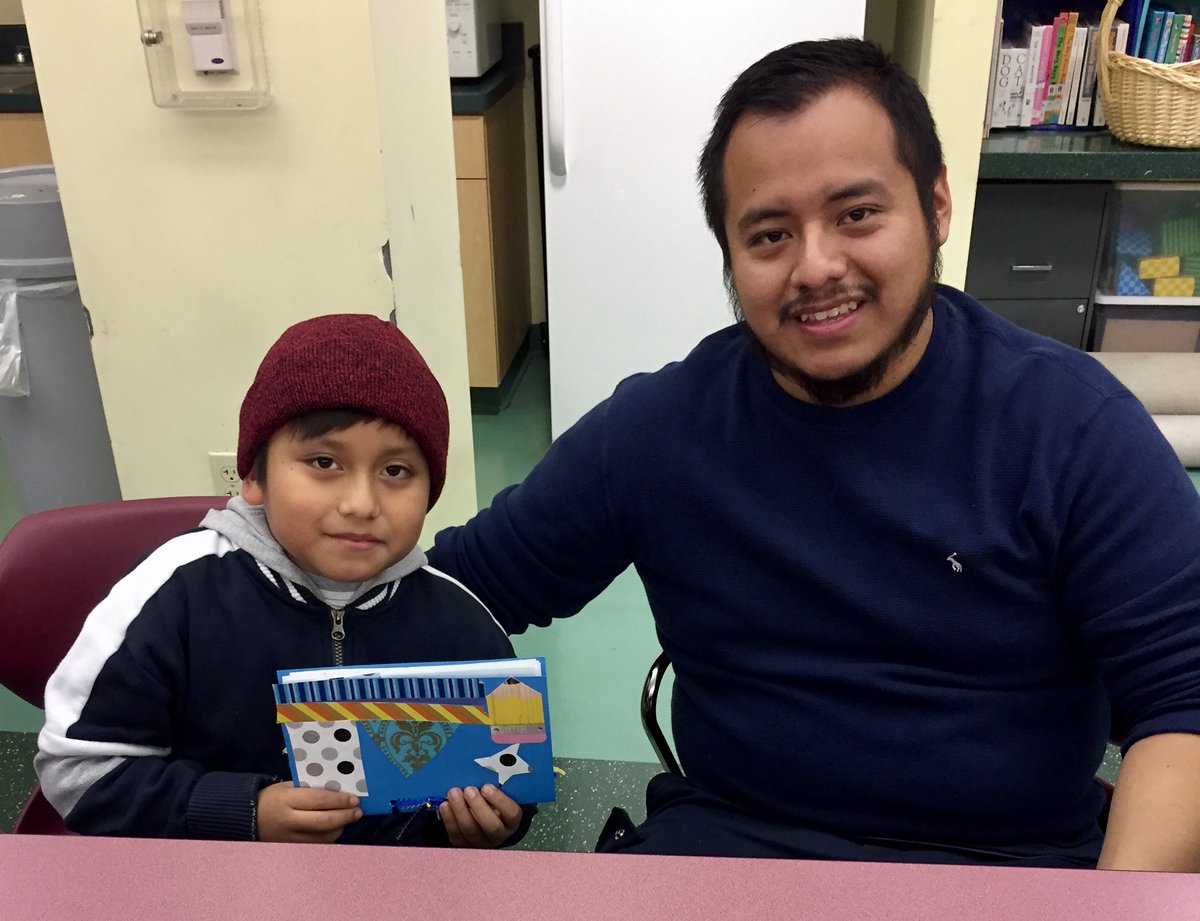 man and child holding craftbook