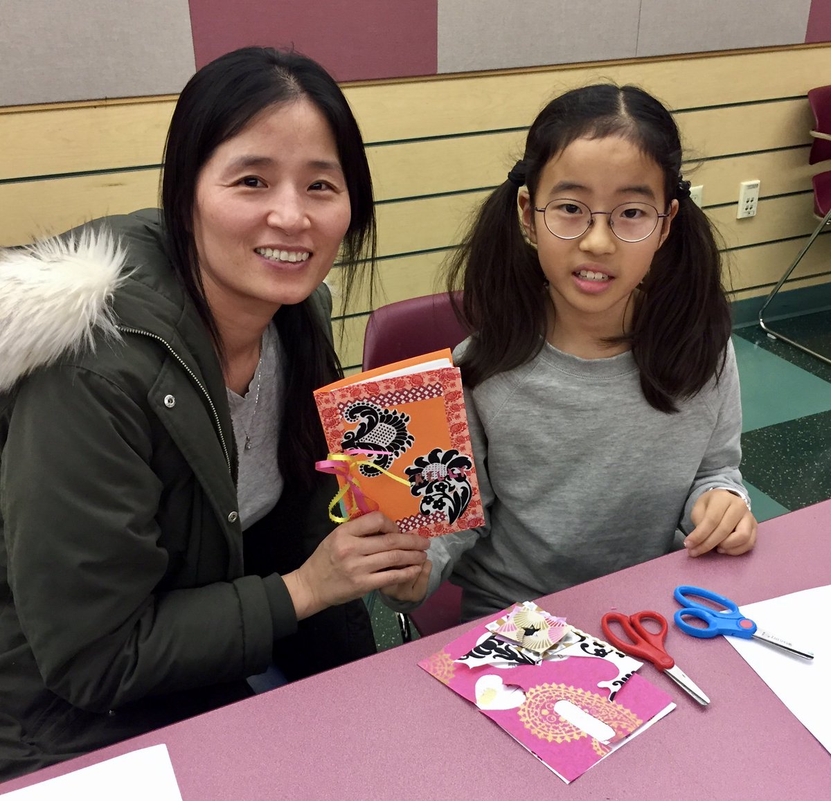 child and woman holding craftbook