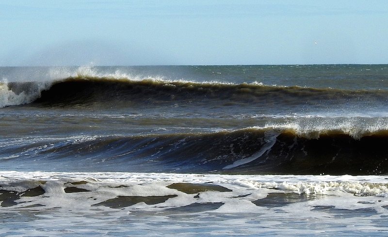 CorollaSurfShop's tweet photo. At this posting Corolla has an outgoing tide, a west wind blowing at 20 mph and thigh high waves. A 20 mph wind is just too much power will knock the juice of the surf down throughout the day.  H20 temp is still about 50 degrees and air temp is 51 degrees. https://t.co/m5EXnilZoQ