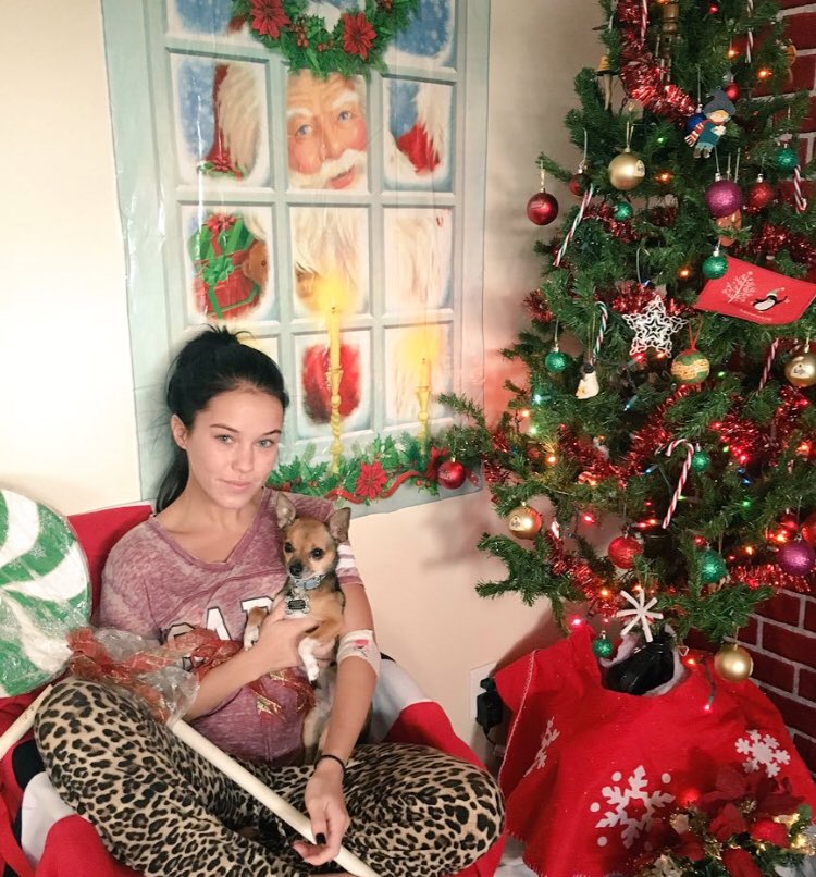 Cuddling this baby by the tree. While wearing -clothes-.