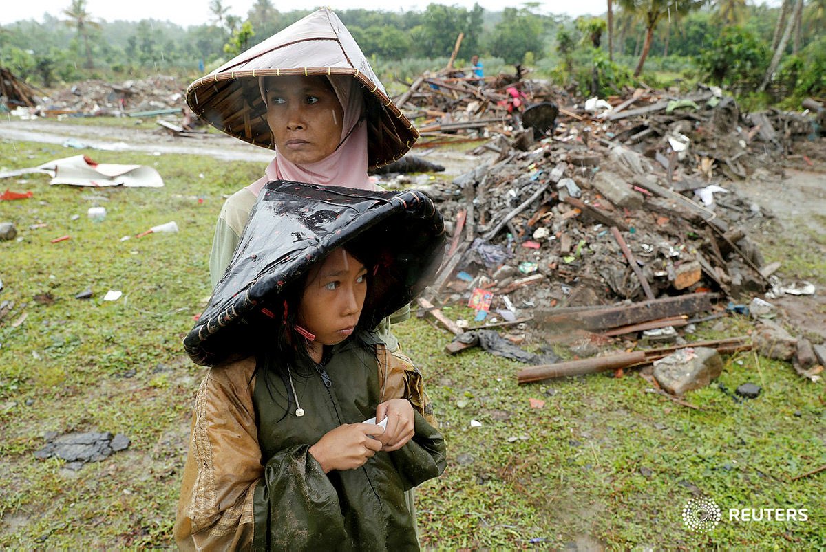 A woman and child are seen next to debris after a #tsunami in #Sumur Banten province, #Indonesia December 26, 2018. REUTERS/Jorge Silva