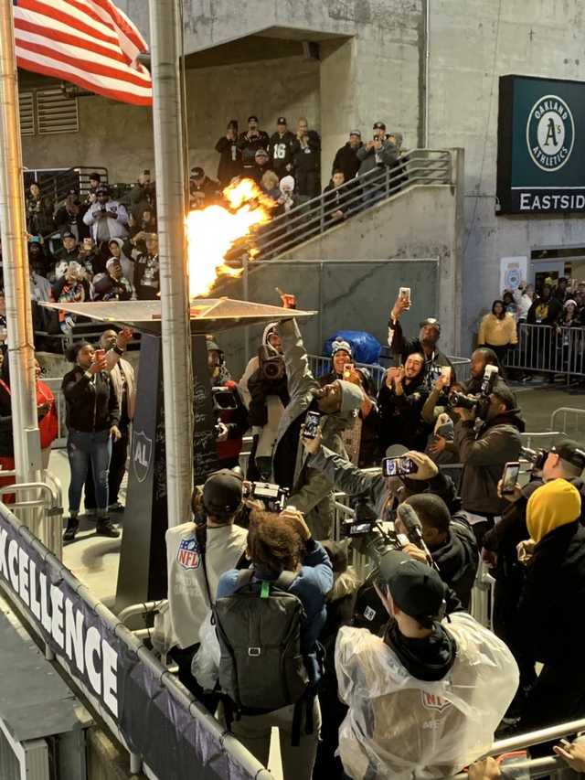 CodyEndres1's tweet image. Marshawn lynch tying to light a blunt off AL Davis eternal flame during last home game. This is art
