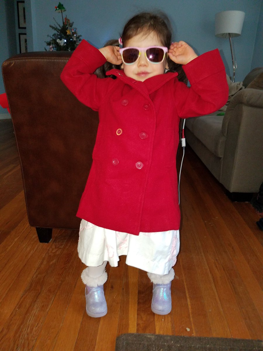 photo of little girl wearing a long red jacket and sunglasses