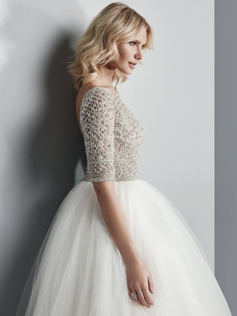 This Sottero&amp;Midgley ballgown is so incredible! It has a sheer bodice of Swarovski crystals and beading atop a voluminous tulle skirt. Complete with half-sleeves, an elegant illusion bateau over sweetheart neckline, and sexy open back. <a href="/maggiesottero/">Maggie Sottero Designs</a>