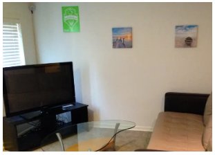 picture of a corner of a living room. the upper lefthand corner contains a camera.