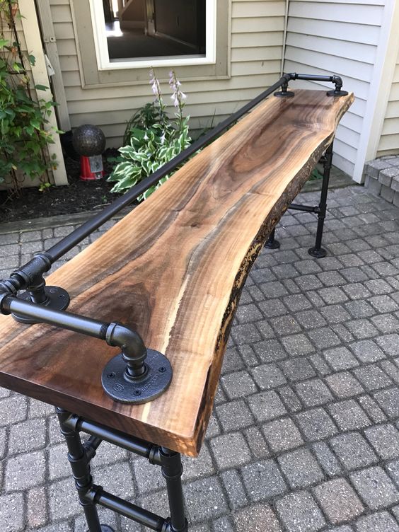 Cool live edge walnut sofa bar table that is so unique and is great for a space behind a couch or sofa for some extra viewing seats! The beautiful live edge wood and steel pipe legs give this piece a unique industrial look while maintaining its rustic feel.