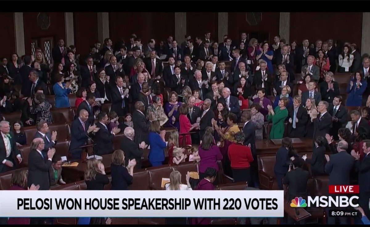 Still from MSNBC video feed showing House of Representatives chamber applauding Nancy Pelosi, chyron reads "PELOSI WON HOUSE SPEAKERSHIP WITH 220 VOTES"