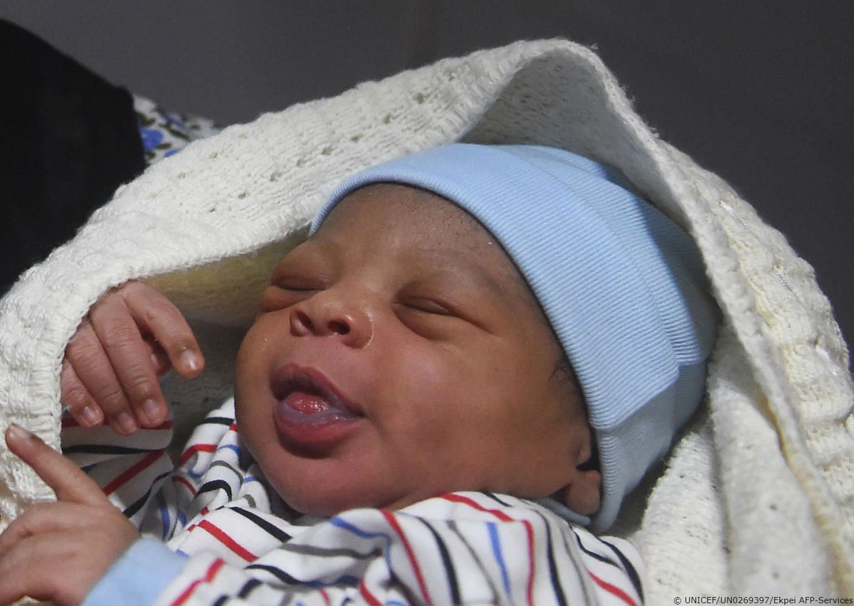 A baby, born on New Year's Day, smiles in the arms of his mother at a hospital in Nigeria.
