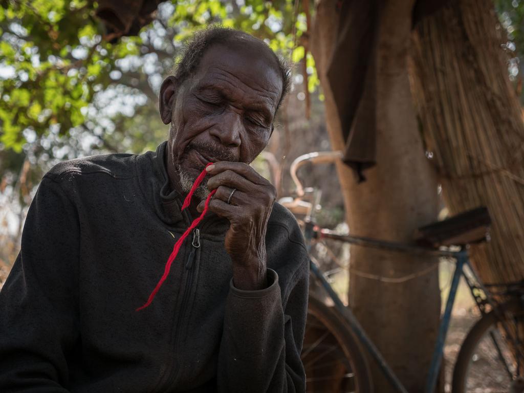 Old Fie-Celenku prepares a thread with incantations in each knot for me to hang on my donso shirt "over the heart, to give you courage"