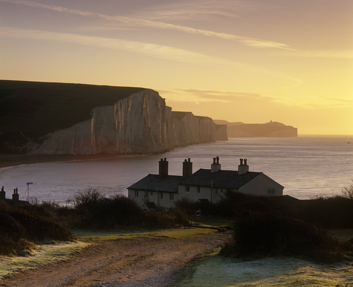 Sunrise over the cliffs at Seven Sisters, with houses in the foreground.
