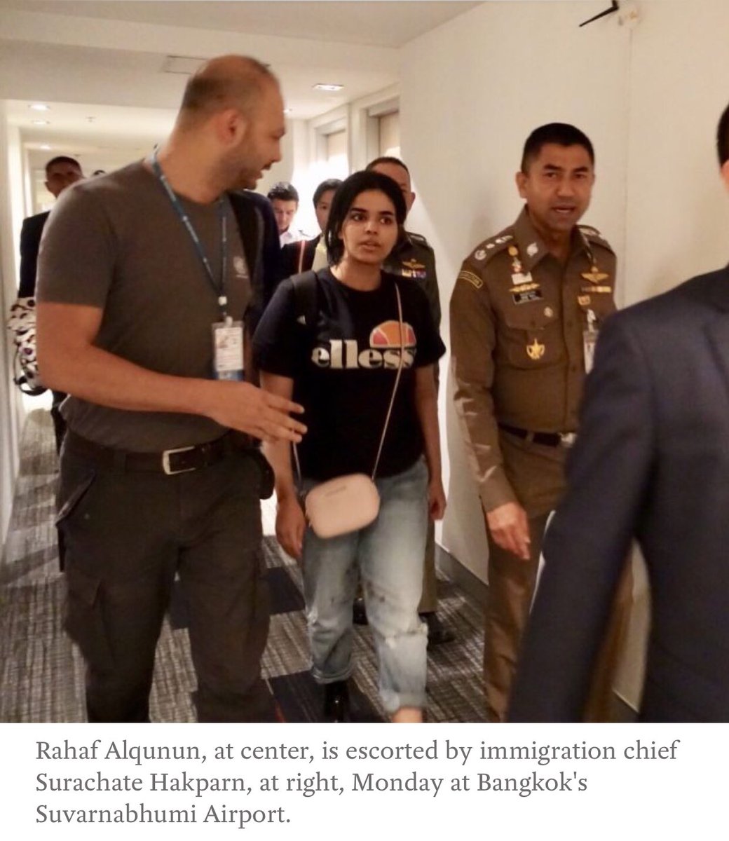 Rahaf Alqunun, at center, is escorted by immigration chief Surachate Hakparn, at right, Monday at Bangkok's Suvarnabhumi Airport.