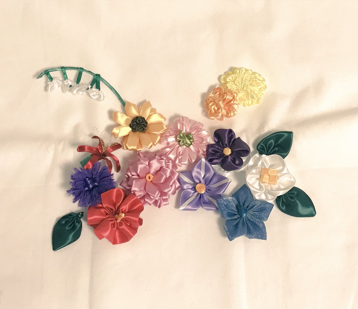 うづき 24日21 00 Booth 13 アザミ 彼岸花の下に 紫のアザミが咲きました 細くトゲトゲした花びらをどう表現するか悩んだ結果 スズランテープ のような素材のリボンを使用してみました 束ねて半分にした後 細かく割いて開いています また 中央の花芯