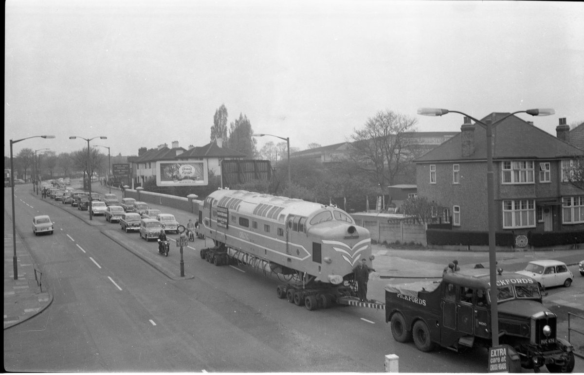 Found this on Facebook recently, the prototype Deltic being moved by road by my old company! A bit worried about the 2 men standing on the drawbar, but love the classic car rally behind the load! (Photo possibly owned by <a href="/DelticPS/">Deltic Preservation</a>, but not clear!) <a href="/pipdunn/">Pip Dunn 🏴󠁧󠁢󠁥󠁮󠁧󠁿🇬🇧🇪🇺</a> <a href="/RAIL/">RAIL Magazine</a> <a href="/CCCuration/">Classic Car Curation</a>