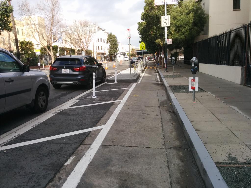 The brand-new protected lane on Valencia! The lead-in parking-protected part is 9'4" wide, while at the school boarding islands it narrows to 5'6" NB / 5'3" SB.