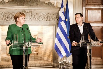 Kanzlerin Merkel steht neben Griechenlands Ministerpräsident Tsipras und spricht bei einer Pressekonferenz ins Mikrofon.