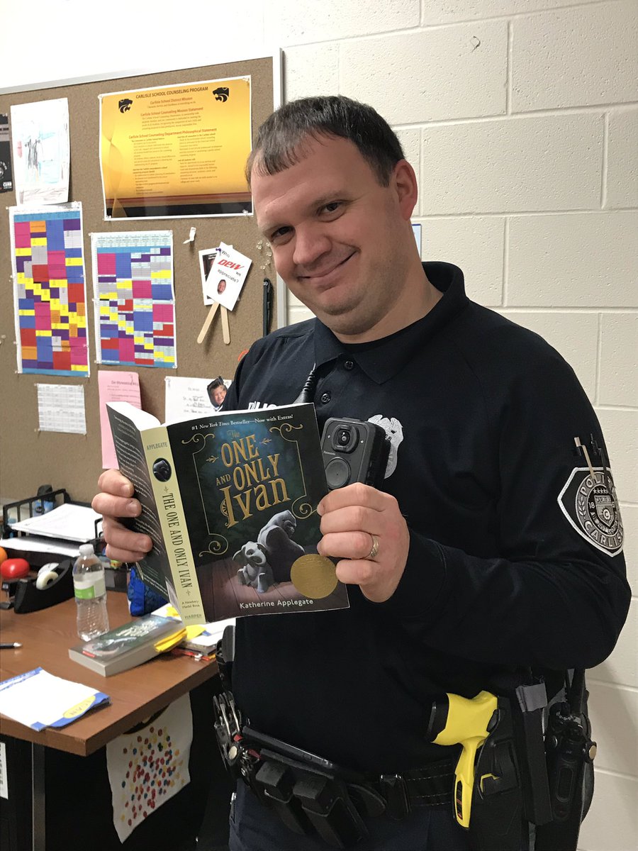 Carlisle_elem's tweet photo. Our Resource Officer, Officer Hauser, is reading the One and Only Ivan! Maybe he will pass it to YOU next! Challenge: @staceydaneedunn @BrandyBaxter1 @Coach_Berryhill  to read it and post a photo! #ireadivan #SmallCatsBigDreams https://t.co/7nXA21mTSL