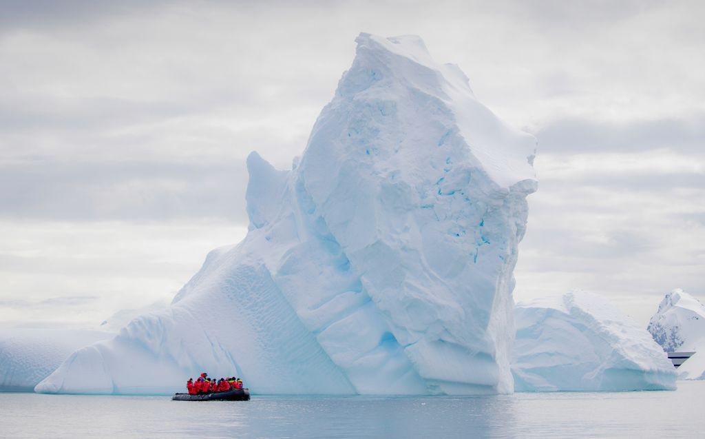 An iceberg dwarfs a zodiac in the #antarctica peninsula. Icebergs are chunks of ice that have calved (broken off from) #glaciers, ice shelves, or a larger #iceberg. They float with ocean currents, sometimes groundout in shallow water or get pushed up against the shore.⠀