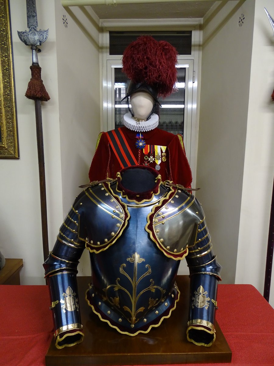 In front is the parade body armour of the Major of the Swiss Guard (who, like all O-4s, is the real worker of the officer corps.) Behind is the Major's ceremonial uniform worn for the many official functions and receptions at which the Swiss Guard always accompany the Pope