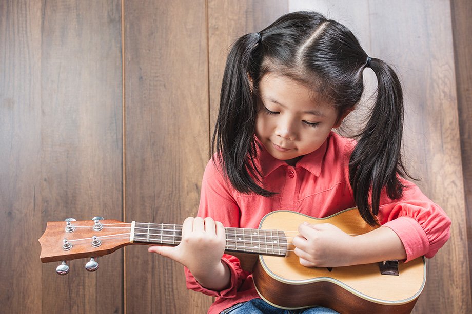 young girl playing ukulele