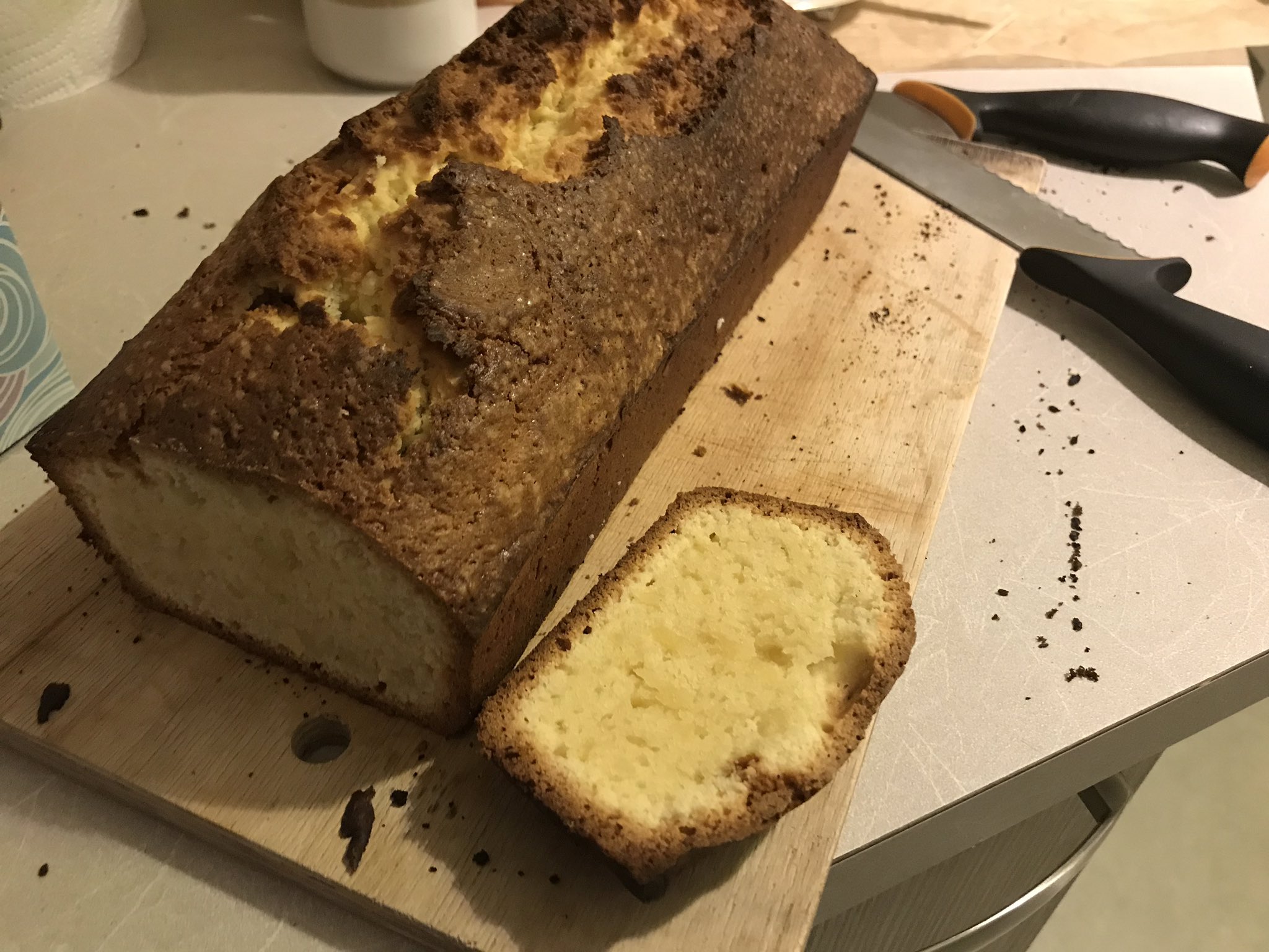An oblong cake, once again with a fairly thick crust (less brown this time). A section has been cut off, showing the yellow and rather dense interior.