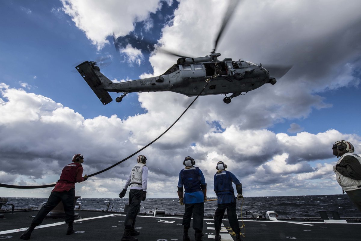 Save time and refuel while you fly! Sailors aboard the #USSPorter refuel an MH-60S Seahawk helicopter as it hovers above the flight deck.
