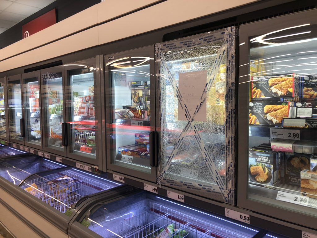 Shambills's tweet photo. @lidl_ireland @H_S_E Day 5. You guys are having a laugh. Total disregard for the safety of the public and your staff. The fridge is actually still in use as is the one below it with the pieces of glass falling to it. #Disgraceful https://t.co/qgsjuidCg9