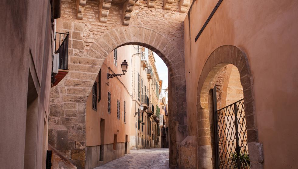 Materials. Towns are built with what is close at hand, usually this means wood, brick or stone. Streets and buildings easily maintained by hand and by locals anchors a town to its location. No global supply chain necessary. Eventually a local character will develop. A rhythm.