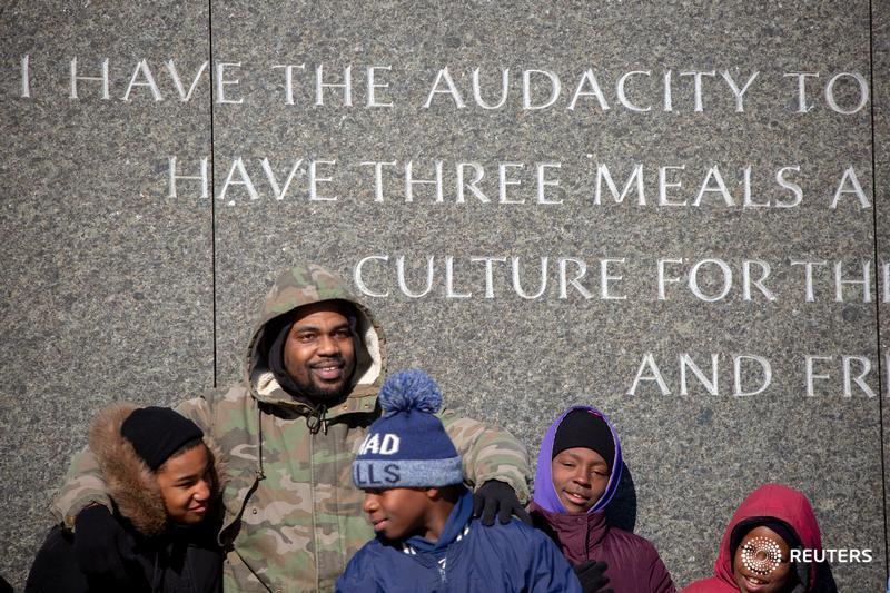 Micah Wilson poses for a photo with youth from the Lenfest Center in Philadelphia, at the Martin Luther King Jr. Memorial in Washington. More images of #MLKDay commemorations: https://reut.rs/2Hm4z6I 📷 Allison Shelley