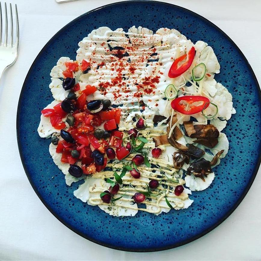 Cauliflower with international flavours by chef Filippo Tawil @filippot22 - Discover this delicious healthy and vegan dish made of thin sliced of raw marinated Cauliflower with Indian, Thai, Italian and Spanish delicious ingredients and flavours.  #cliniquelaprairie #healthyfood