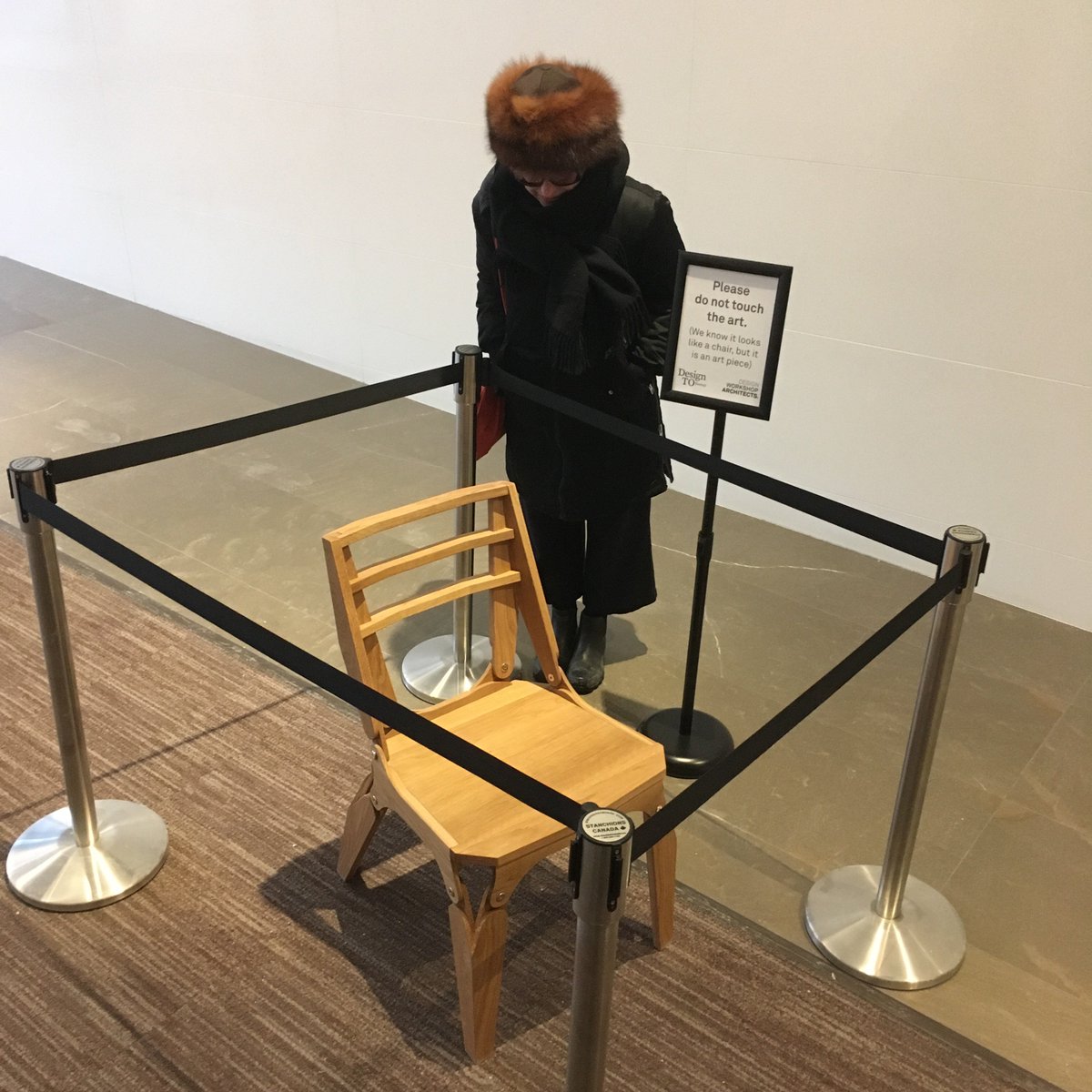 Trustcate's tweet image. Two wooden chairs, one big/one small, by @dwa_arc are meant to be a parable about conversations and finding common ground btw differing POVs. The roping off of the little one wasn't planned, but adds another metaphoric layer. #DesignTO #DesignTO19 On view 351 King St E #toronto