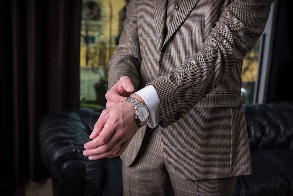 Traje tres piezas color marrón con estampado de cuadro ventana azul y micro pata de gallo.  

1.Chaqueta de dos botones y solapa de muesca.   
2.Chaleco de ocho botones sin solapa y acabado en pico.   
3.Pantalón de corte slim sin pinzas.  
4.Camisa con puño doble para gemelos.