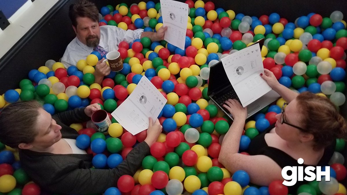 People working in office attire while surrounded by ball pit balls.