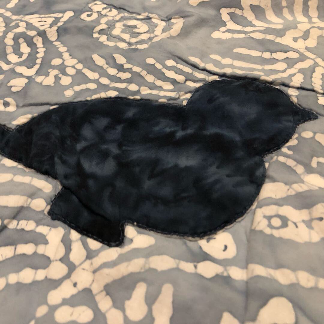 Penchant4Words's tweet image. #TBT to one of my favorite quilts! It’s truly a twin, folded in the middle to show everything! I got this gorgeous batik print in Wrangell, Alaska. It reminded me of all the petroglyphs carved into stones on the beach there! In the tree bark are ee cummings quotes. 
#sewfun