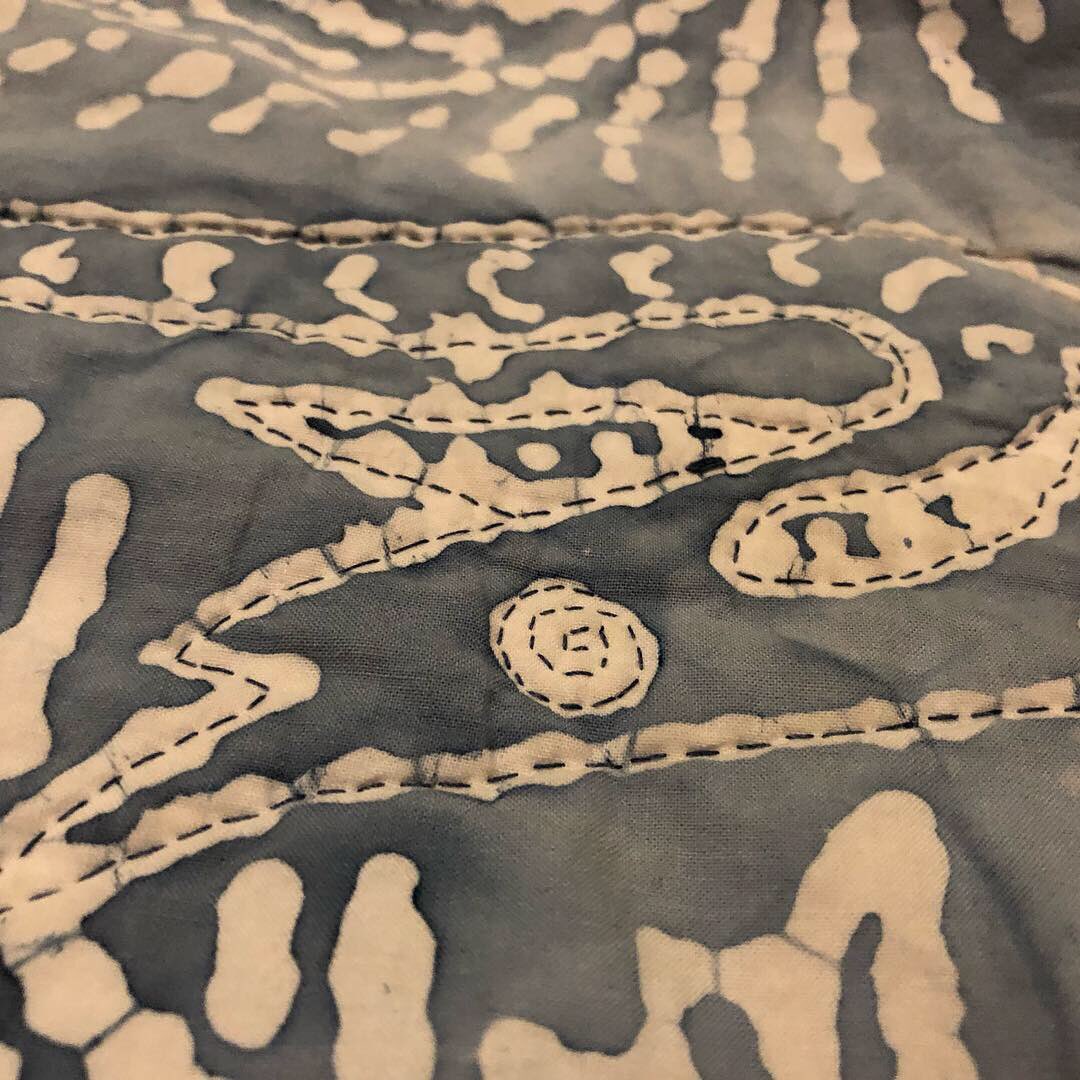 Penchant4Words's tweet image. #TBT to one of my favorite quilts! It’s truly a twin, folded in the middle to show everything! I got this gorgeous batik print in Wrangell, Alaska. It reminded me of all the petroglyphs carved into stones on the beach there! In the tree bark are ee cummings quotes. 
#sewfun