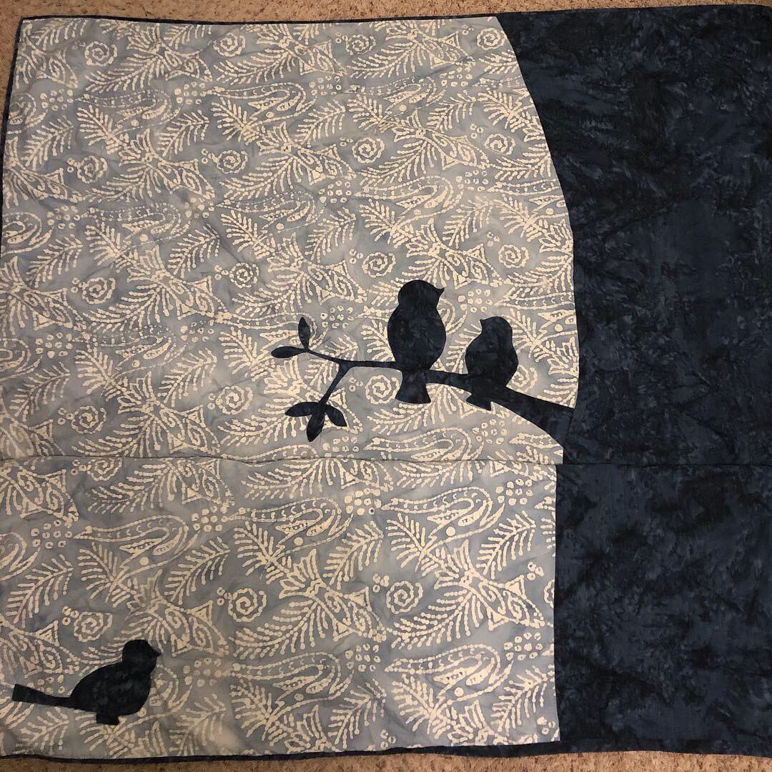 Penchant4Words's tweet image. #TBT to one of my favorite quilts! It’s truly a twin, folded in the middle to show everything! I got this gorgeous batik print in Wrangell, Alaska. It reminded me of all the petroglyphs carved into stones on the beach there! In the tree bark are ee cummings quotes. 
#sewfun