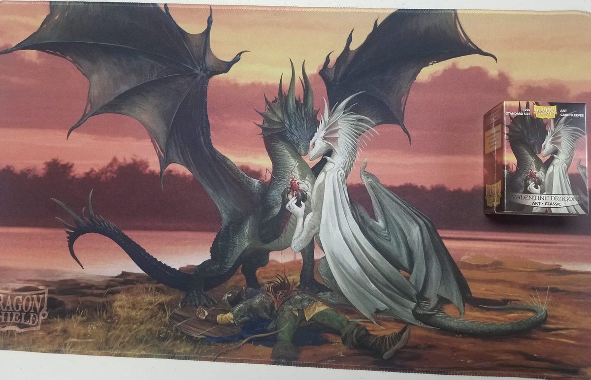 This new playmat and deck sleeve combo are the perfect Valentine’s Day gift for that special someone who games! Featuring a pair of dragons sharing the heart of a freshly defeated knight who dare thought to smite them! Limited print run! Get them today!