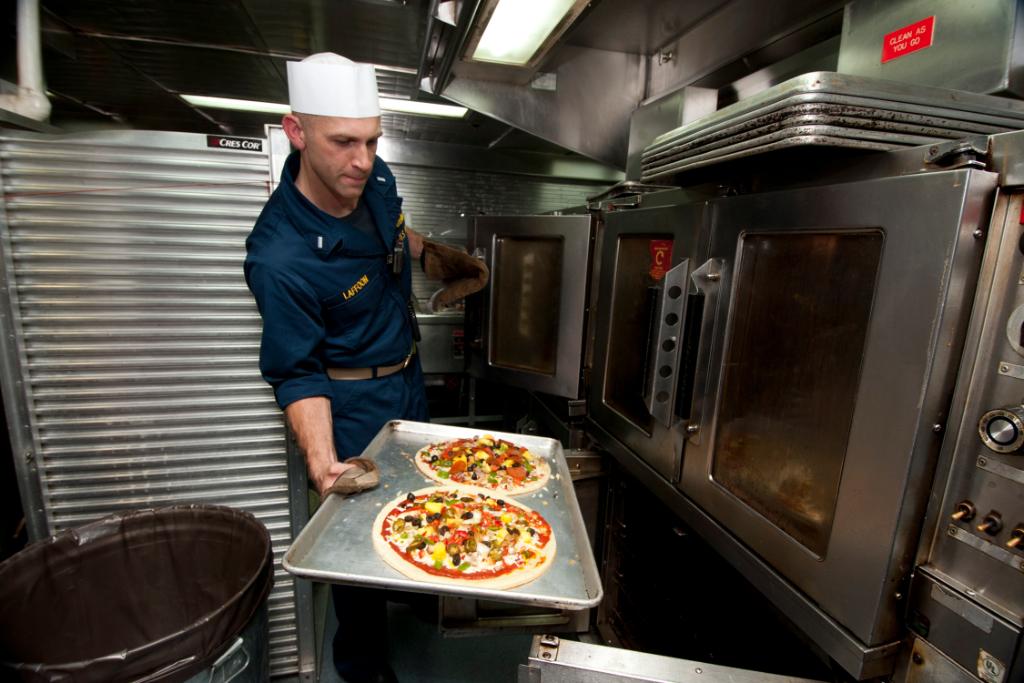 USNavy's tweet photo. Fresh, hot pizza provides a slice of home when you're on deployment operating forward to protect and defend America and preserve our strategic influence around the globe. Happy #NationalPizzaDay! https://t.co/92FMccBybD