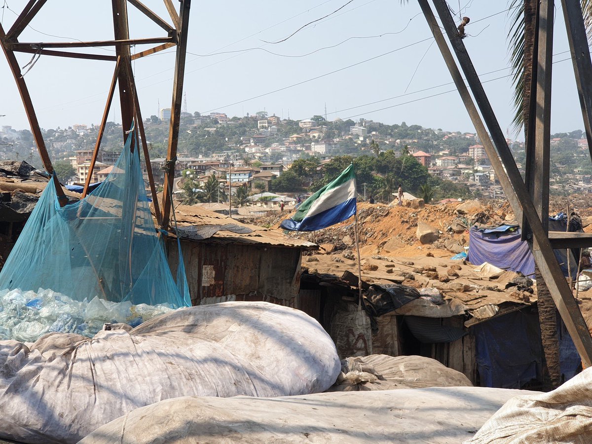 UmaruFofana's tweet image. They live on and by the dump - literally. They have known only Kingtom Bormeh in #SierraLeone’s Capital as home. They sleep there &amp;amp; make a living scavenging there. But even in the face of the gross state neglect of them, they still fly the country's flag on their shack.